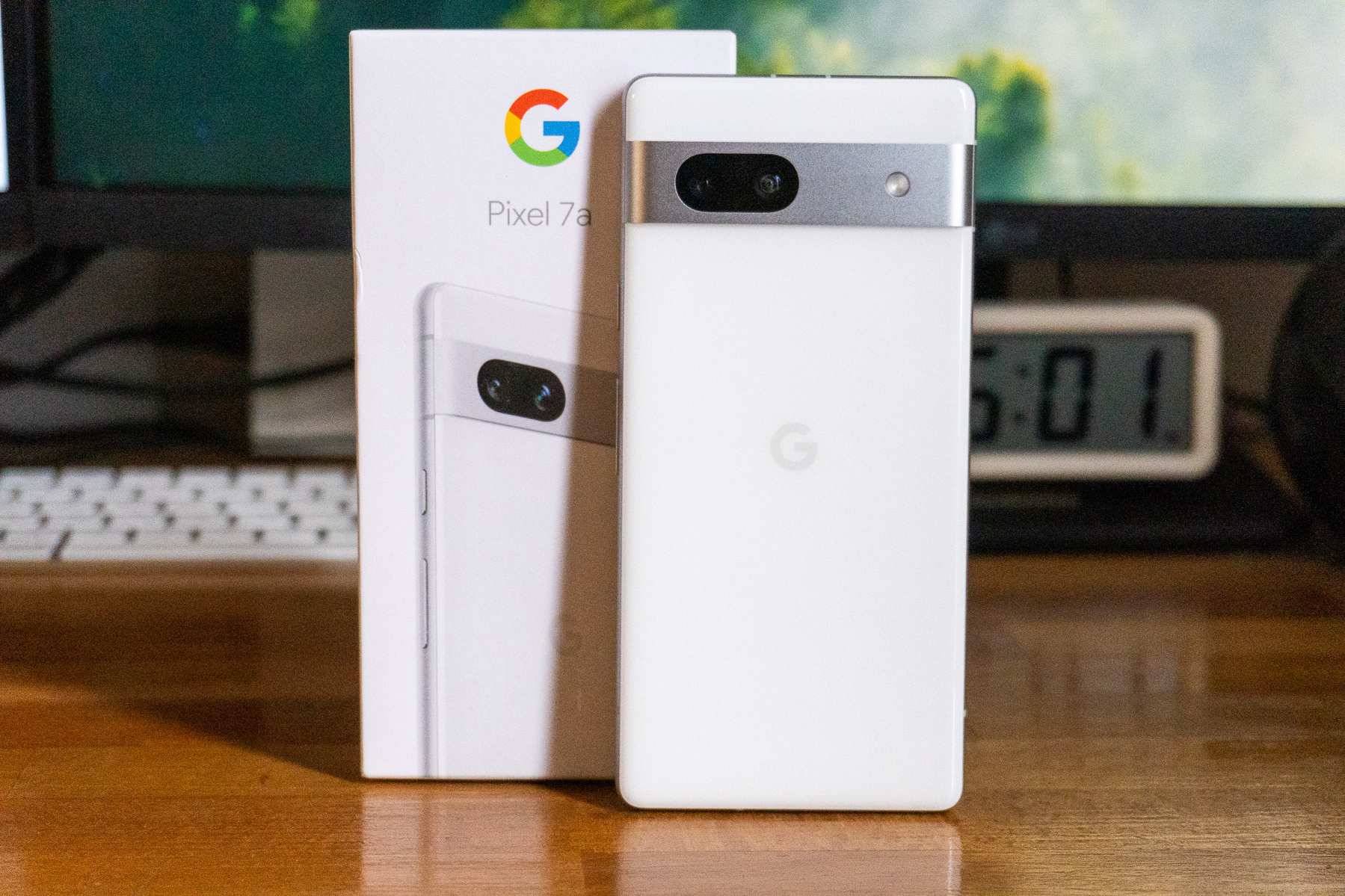 Auto-generated description: A Google Pixel 7a smartphone is displayed in front of its box.